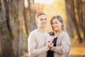 Loving couple cuddles in warm bright sweaters holding dwarf dog in their hands. Childfree Concept Royalty Free Stock Photo