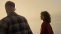 Loving couple dating on beach at sunrise. Woman and man walking on seashore. Royalty Free Stock Photo