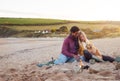 Loving Couple With Dog Relaxing By Fire On Winter Beach Vacation Royalty Free Stock Photo