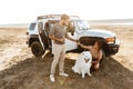 Loving couple with dog samoyed outdoors near car Royalty Free Stock Photo