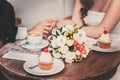 Loving couple drink coffee after the wedding. Hands newlyweds