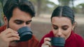 Loving couple drinking beverage at picnic on nature closeup. Romantic pair relax