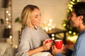 Loving couple drinking tea in front of Christmas tree Royalty Free Stock Photo