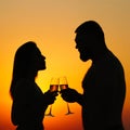 Loving couple drinking wine or champagne during sunset time, silhouette of a couple with wineglasses on sunset background, man and Royalty Free Stock Photo