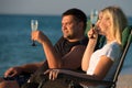 A loving couple drinks champagne on the beach. Romantic. Royalty Free Stock Photo