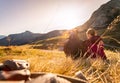 Loving couple is enjoying the sundown in the mountains, sitting on the ground. Warm colors, alps, Austria Royalty Free Stock Photo