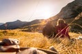 Loving couple is enjoying the sundown in the mountains, sitting on the ground. Warm colors, alps, Austria Royalty Free Stock Photo