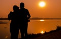 Loving couple enjoying the sunset over the river Royalty Free Stock Photo