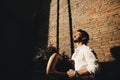 Loving couple enjoying a walk in the city. Behind them is the background is a red brick wall