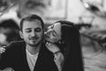 Loving couple. Girl hugs her boyfriend sitting in the cozy romantic cafe. Black and white photo