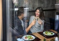 Loving couple with glasses of champagne in restaurant on romantic date, view through glass window Royalty Free Stock Photo