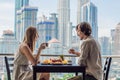 Loving couple having breakfast on the balcony. Breakfast table with coffee fruit and bread croisant on a balcony against Royalty Free Stock Photo