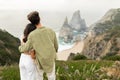 Couple having romantic date, guy embracing lady, standing back to camera, enjoying beautiful view at ocean shore Royalty Free Stock Photo