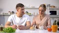 Loving couple having tea and communicating at kitchen, eating cake, happiness