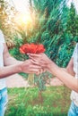 Loving couple holding a bouquet of tulips on a background of beautiful trees. A man gives his beloved flowers