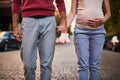 Loving couple holding hands while standing with baby booties on the road Royalty Free Stock Photo