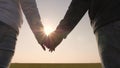 Loving couple holding hands at sunset. Extend your hand to a friend. sun`s rays shine through your fingers. Love