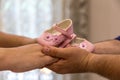 Loving couple holding pink baby girl shoes with care and support Royalty Free Stock Photo