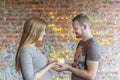 The loving couple holds the burning candle in hand. The woman is pregnant.