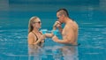 The loving couple hugs and kisses, drinking blue cocktail alcohol liquor in swimming pool at hotel outdoor. Portrait of Royalty Free Stock Photo