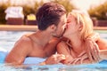 Loving Couple On Inflatable Kissing On Summer Vacation In Outdoor Swimming Pool