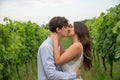 Loving couple kiss while they are in the middle of the grape fields, young passionate lovers