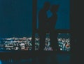 A loving couple are kissing on the background of the panoramic windows overlooking the city at night and the starry sky Royalty Free Stock Photo