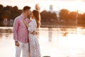 Loving couple kissing on the lake at sunset. Beautiful young couple in love walking on the shore of the lake at sunset in the rays Royalty Free Stock Photo