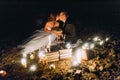 Loving couple kissing on romantic dinner with candles and cake at beach, coast against wonderful night Royalty Free Stock Photo