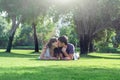 Loving couple lies on grass in park on sunny day, looking at camera. Happy young woman and man on honeymoon. Romantic lifestyle Royalty Free Stock Photo
