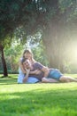 Loving couple lies on grass in park on sunny day, looking at camera. Happy young woman and man on honeymoon. Romantic lifestyle Royalty Free Stock Photo