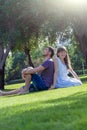 Loving couple lies on grass in park on sunny day, looking at camera. Happy young woman and man on honeymoon. Romantic lifestyle Royalty Free Stock Photo