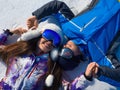 Loving couple lies in the snow while relaxing on a ski slope in a ski resort. Royalty Free Stock Photo