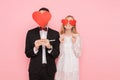 Loving couple in love, man and woman with red hearts on their eyes, over pink background. Lovers day concept