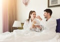 Loving couple lying on bed and having breakfast Royalty Free Stock Photo