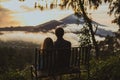 A loving couple, a man and a woman sitting near Batur volcano. Sunrise, sunset