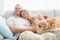 Loving couple napping on couch with their dog Royalty Free Stock Photo