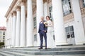 Loving couple of newlyweds walks in the city near columns