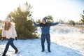 Loving couple play snowballs in winter in the forest. The guy sculpts and throws snowballs at the girl. Laugh and have a good time Royalty Free Stock Photo