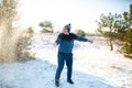 Loving couple play snowballs in winter in the forest. The guy sculpts and throws snowballs at the girl. Laugh and have a good time Royalty Free Stock Photo