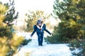 Loving couple play in the winter in the forest. Girl rides a guy in the background of the Christmas tree. Laugh and have a good Royalty Free Stock Photo