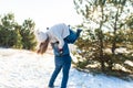 Loving couple play in the winter in the forest. The guy threw the girl on his back and runs with her through the forest. Laugh and Royalty Free Stock Photo