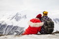 A loving couple plays together in the snow outdoors. Winter holidays in the mountains.