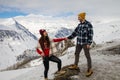 A loving couple plays together in the snow outdoors. Winter holidays in the mountains.