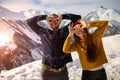 A loving couple plays together in the snow outdoors. Winter holidays in the mountains.