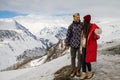 A loving couple plays together in the snow outdoors. Winter holidays in the mountains.