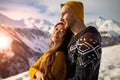 A loving couple plays together in the snow outdoors. Winter holidays in the mountains.