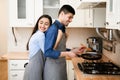 Loving couple preparing dinner frying meat on pan Royalty Free Stock Photo