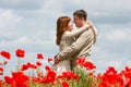 Loving couple on red poppies field Royalty Free Stock Photo