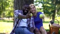 Loving couple showing green apples into camera, choosing healthy products